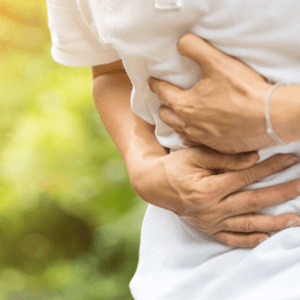 A man holding his stomach from abdominal pain with poor gut health