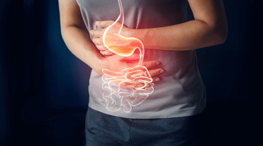 A person holding their stomach due to poor gut health symptoms and pain